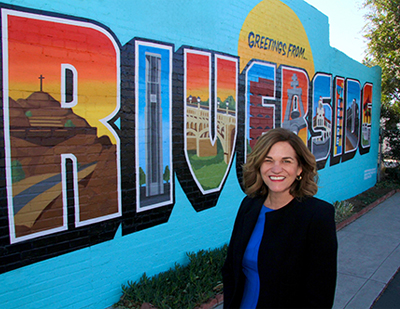 Mayor Lock Dawson standing in front of the Riverside mural 
